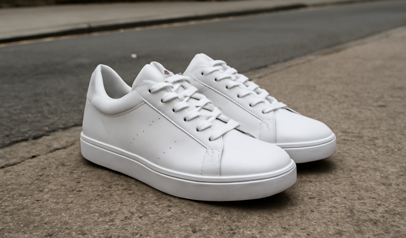 paire de baskets blanches sur sol urbain