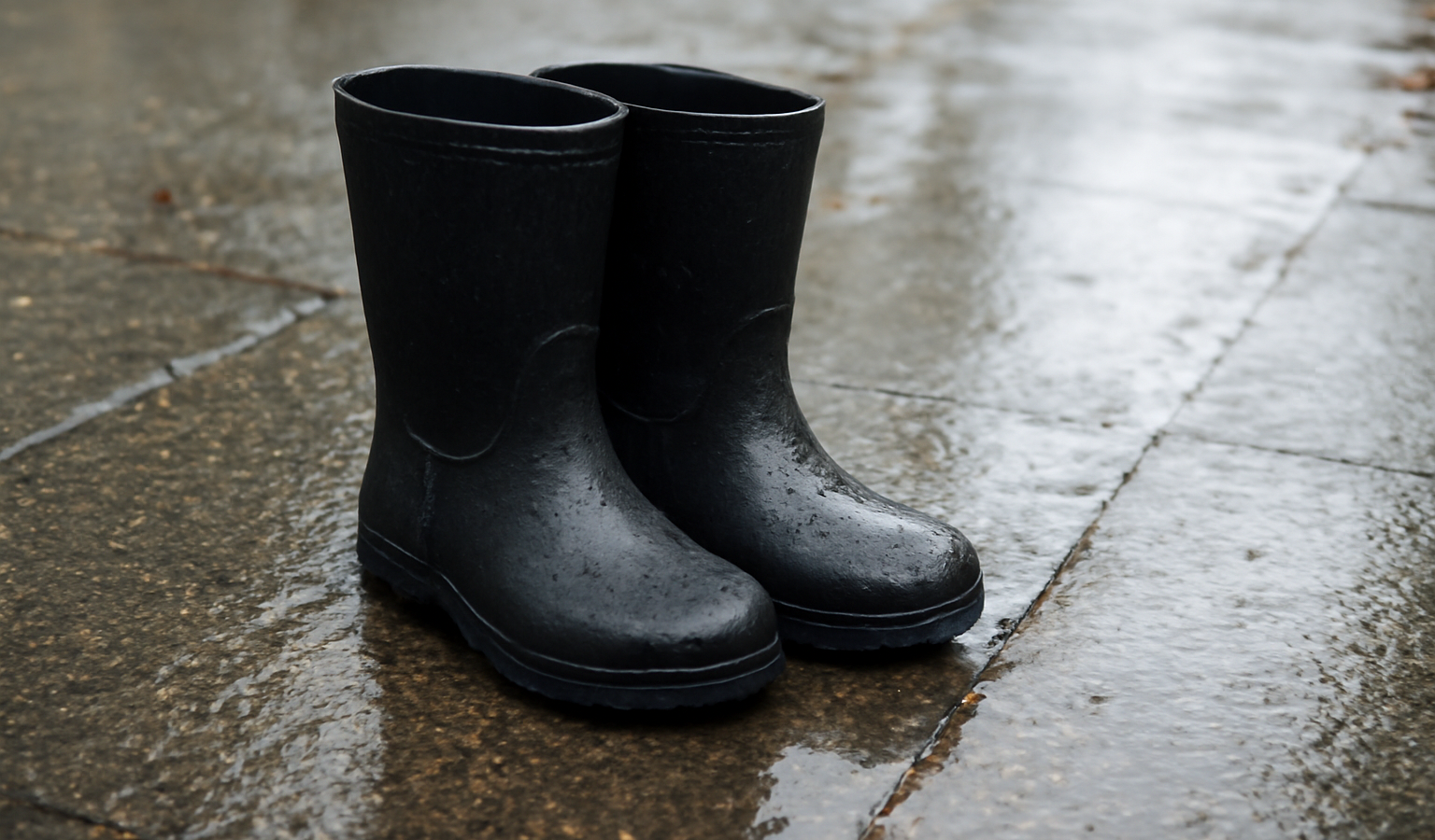 bottes imperméables posées sur trottoir mouillé