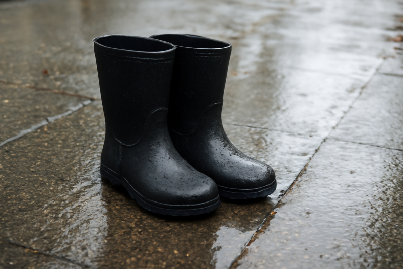 bottes imperméables posées sur trottoir mouillé