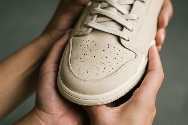 mains tenant une chaussure montrant l'avant-pied