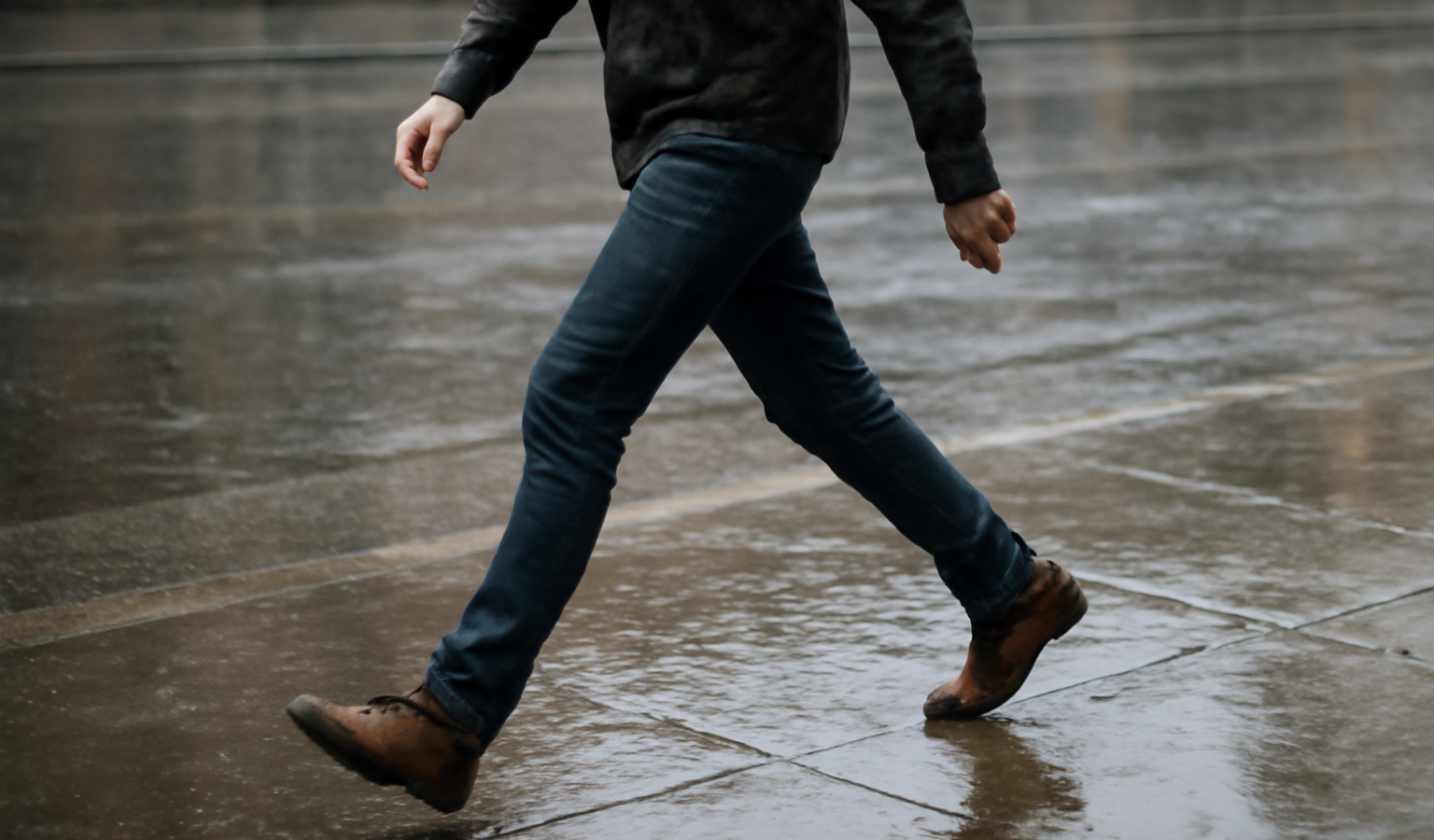 personne marchant vite sur trottoir mouillé